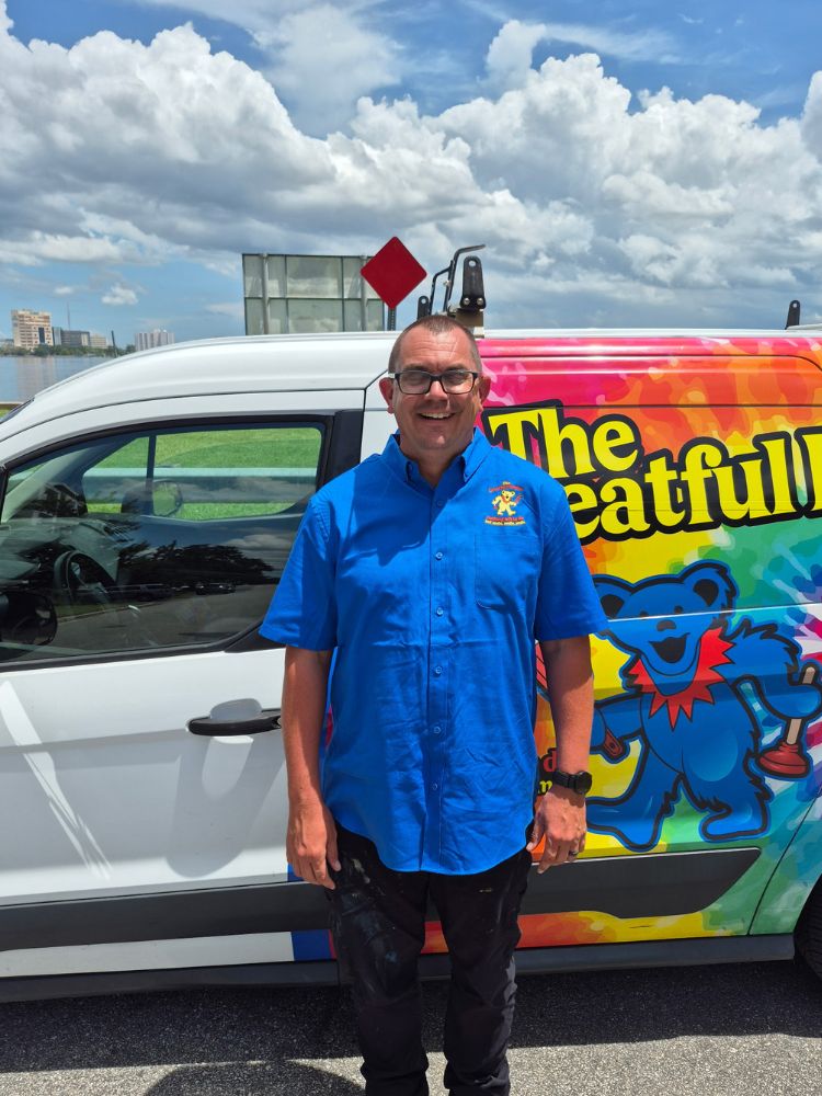 Danny, professional plumber standing next to The Greatful Plumber service van with St. Johns River in background, Jacksonville Florida