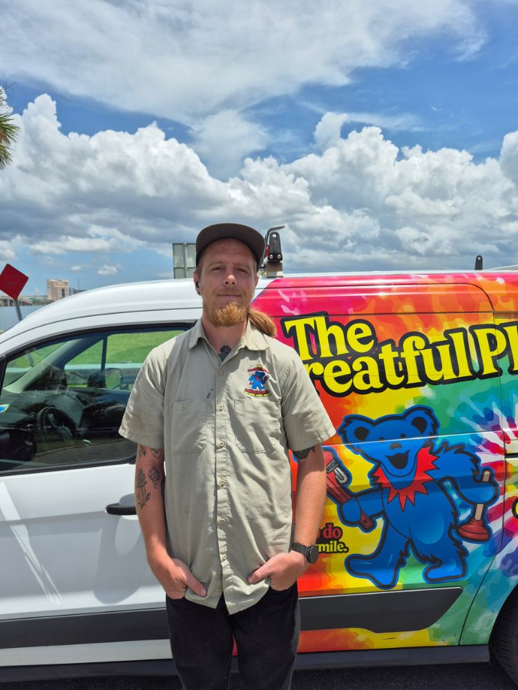 Harrison, experienced plumber with 8 years experience in Orlando and Jacksonville areas, standing next to The Greatful Plumber service van in Jacksonville Florida
