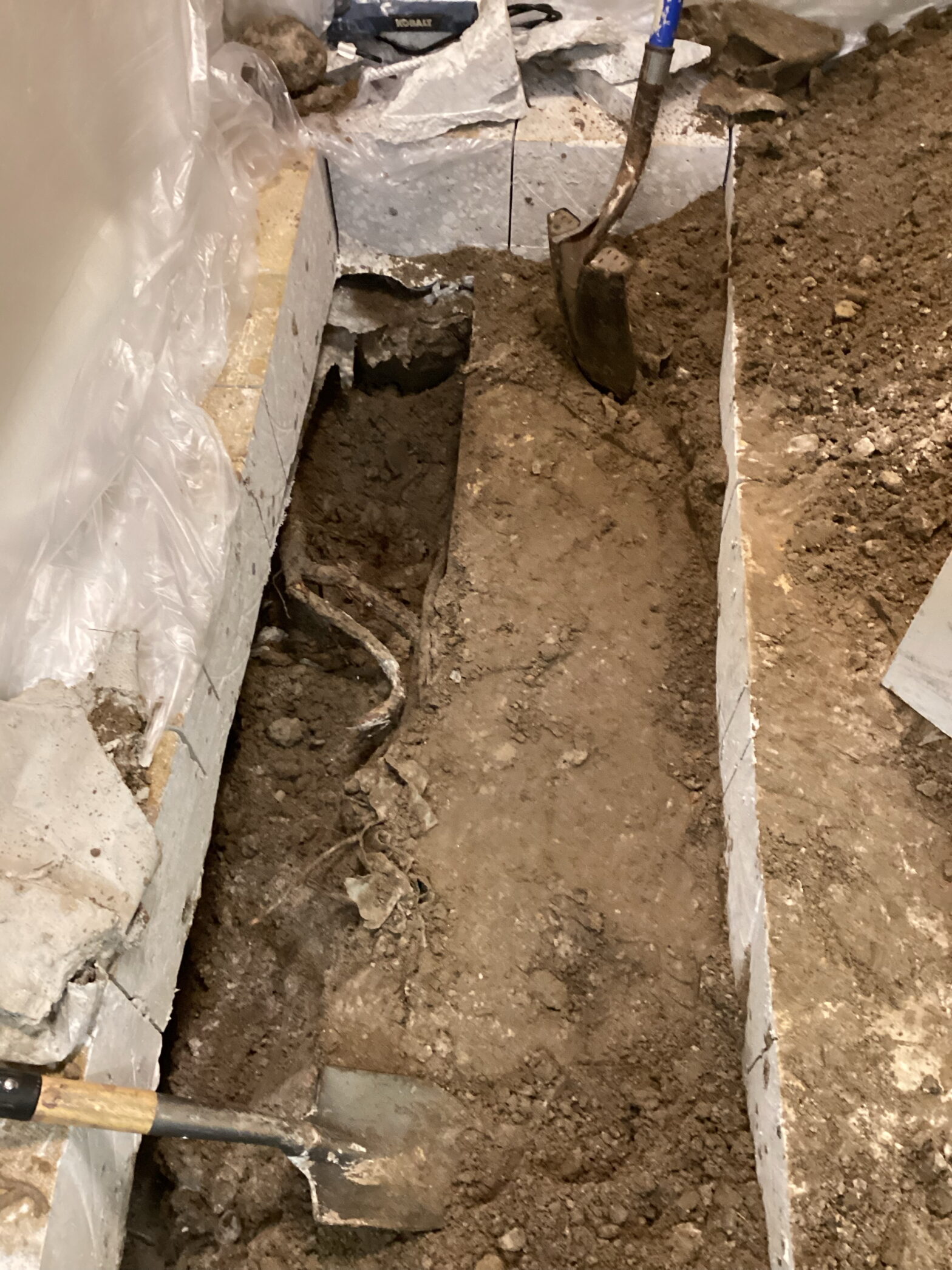 Major plumbing disaster requiring excavation and concrete removal in commercial building, showing the extensive damage and repair work needed for business continuity