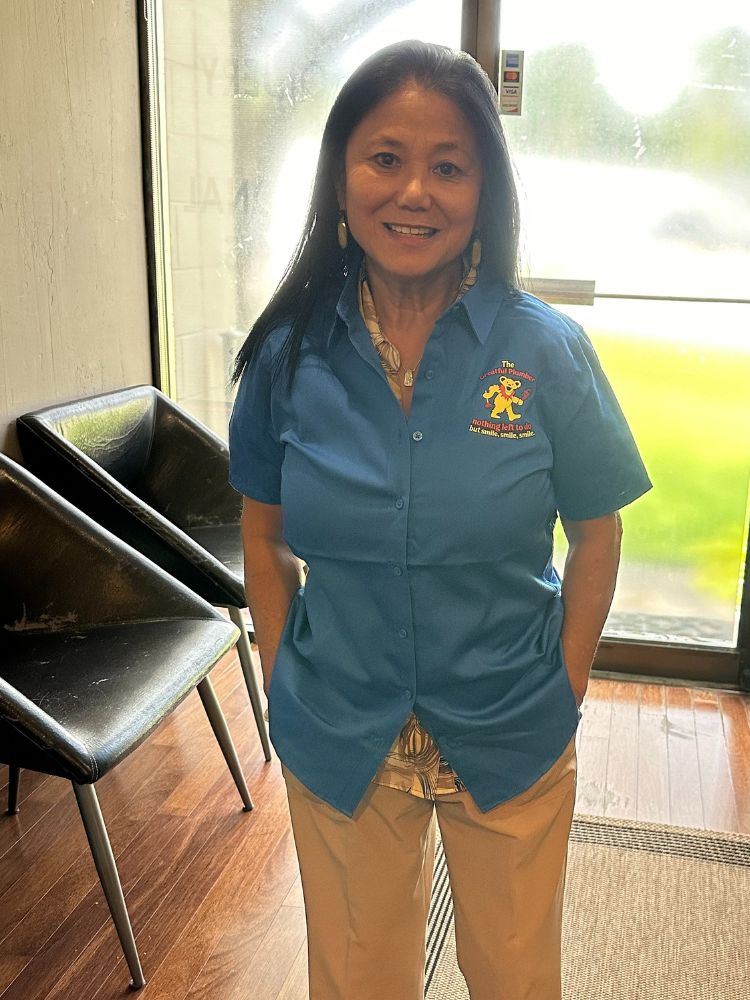 Thuy, office manager at The Greatful Plumber, wearing company uniform in Jacksonville office
