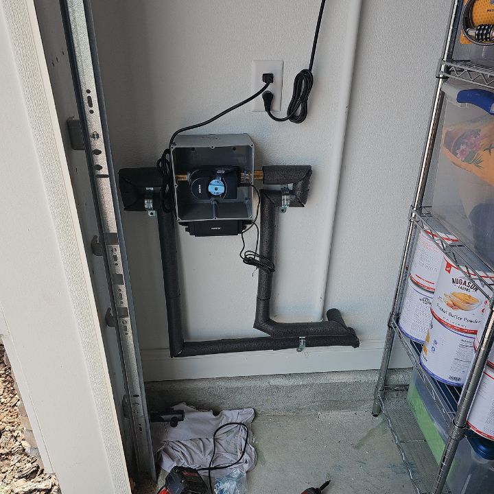 Full view of installed Moen Flo smart water monitoring system with control unit and piping