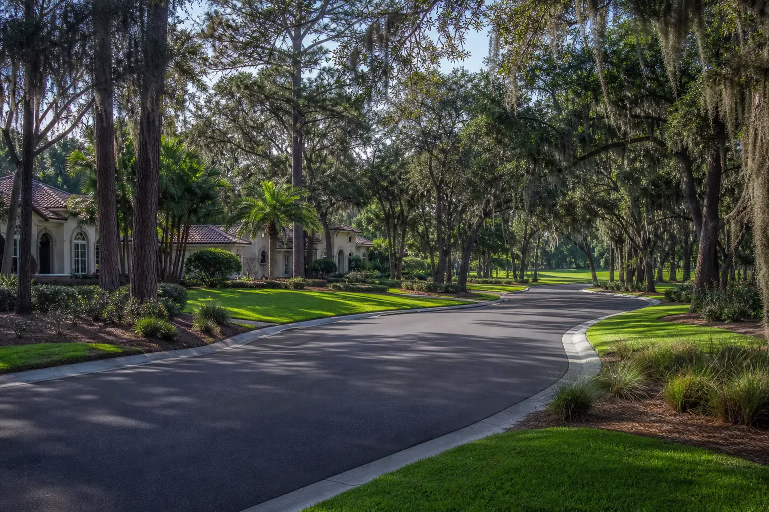 Wide curving street through an upscale gated golf community lined with pines and moss-draped oaks, Deercreek in southside Jacksonville