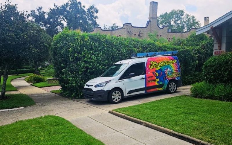 The Greatful Plumber colorful tie-dye service van parked on street in Murray Hill Jacksonville historic neighborhood with vintage bungalow homes